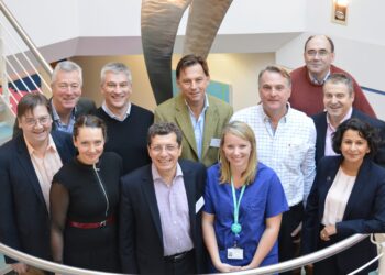 Group of people smiling on staircase.