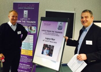 Lapco Norway trainers smiling next to whiteboard.